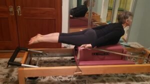 photo of the Pilates exercise called Pulling Straps on a classical Pilates reformer.